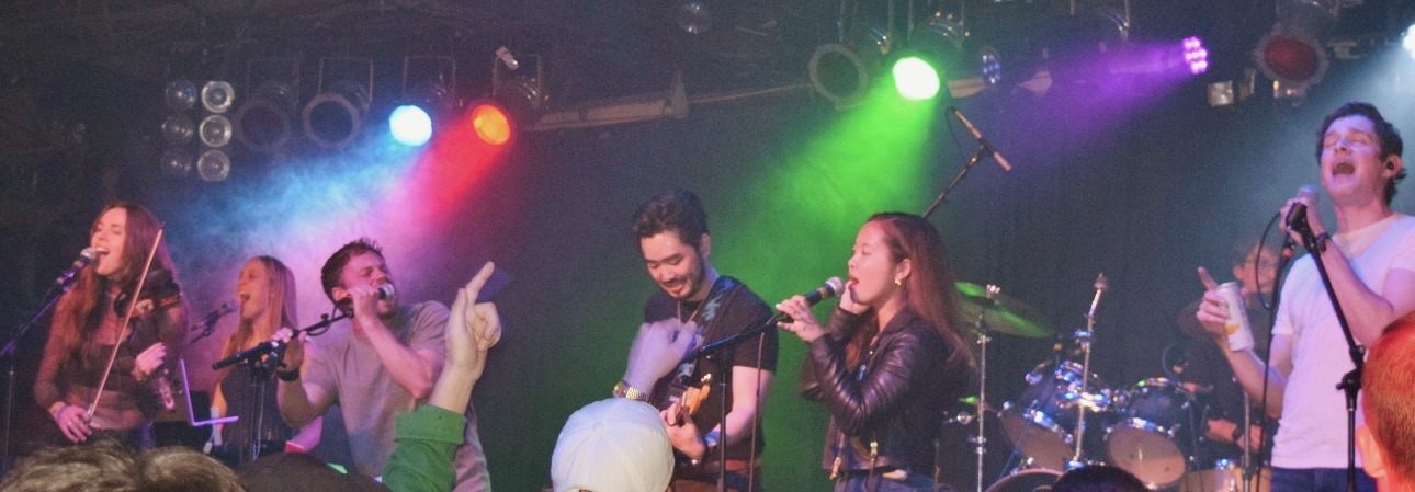 Friends From School performing live, panoramic stage shot